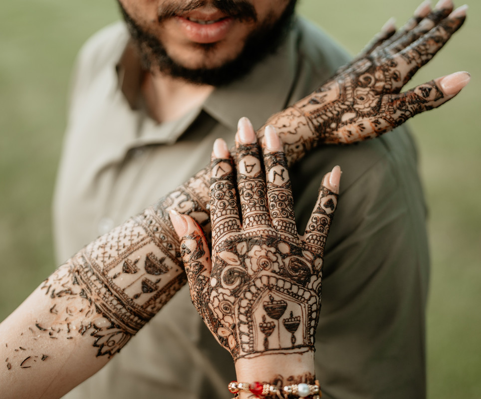 Bride showing her detailed mehndi, with the groom’s name hidden on her fingers